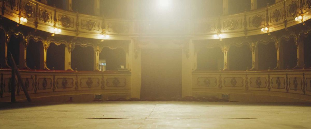Wide shot of an elegant classic theatre with spotlight shot from the stage