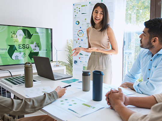 A woman presenting an environmental, social, and governance (ESG) diagram in a meeting room