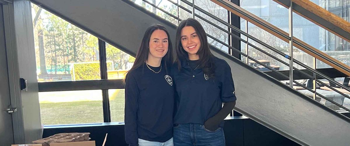 Celia “Cece” Carl poses behind a table with BUPD branding and merchandise