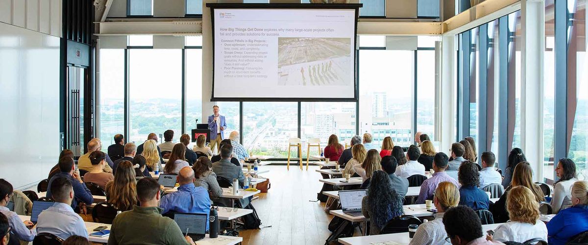 A speaker delivers a presentation to a large crowd at the 2025 PMiP Conference