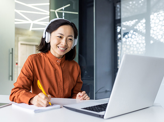 Student taking an online course on a laptop in an office environment