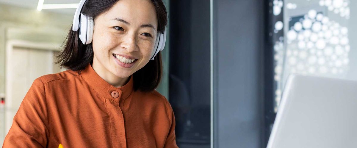 Student taking an online course on a laptop in an office environment