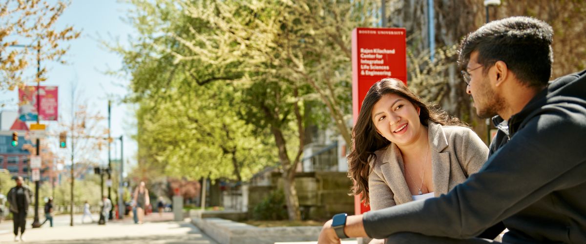 Students sitting outside of CDS Building on a sunny day
