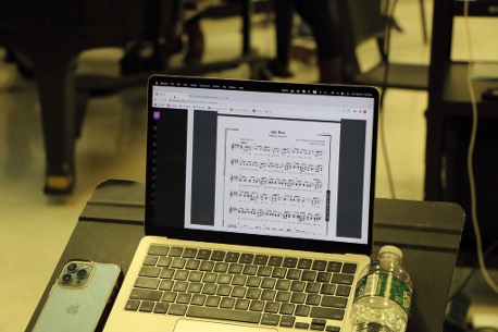 Sheet music visible on the screen of a laptop in a classroom