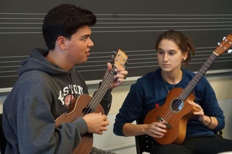 Two students learning to play the guitar