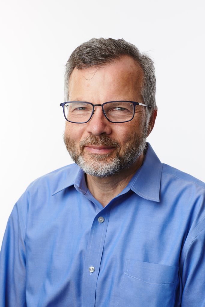 professor with glasses in a blue shirt