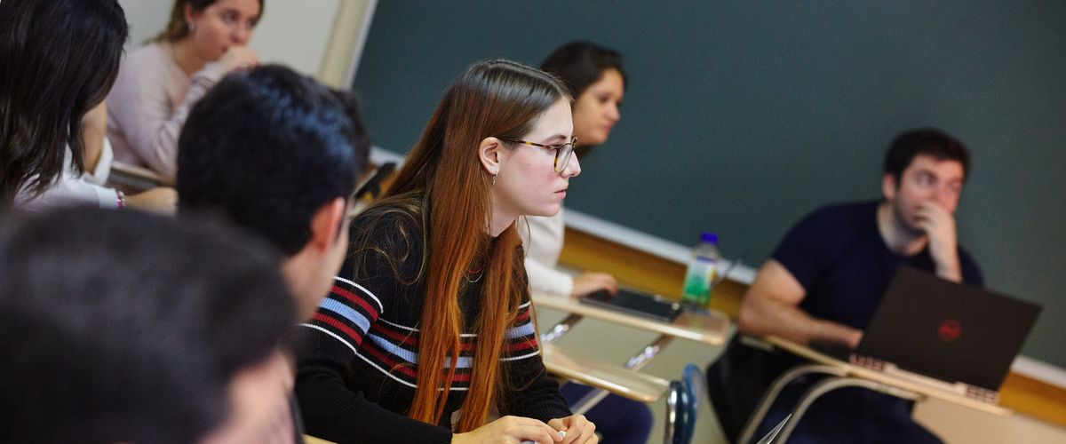 Students at desks attentively looking toward an off-camera professor