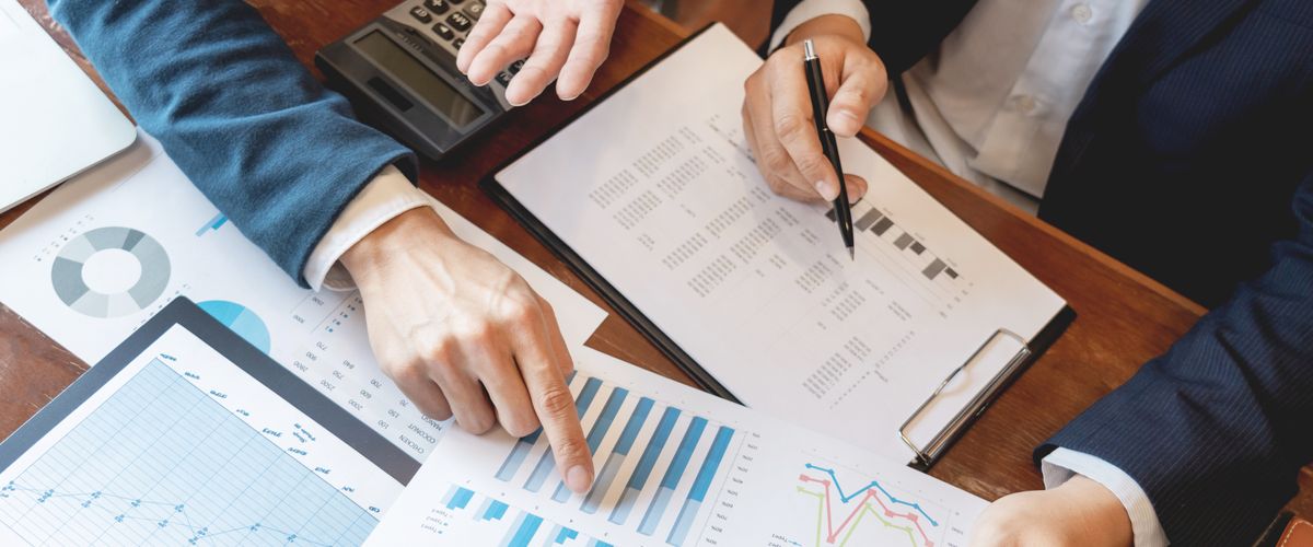 stock image of finance charts being held by two faceless people