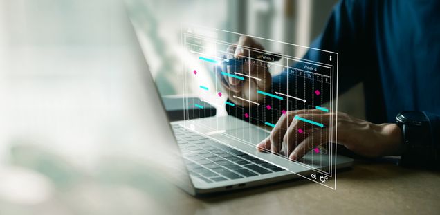 Hands at a laptop keyboard. A calendar schedule is superimposed over the keyboard.
