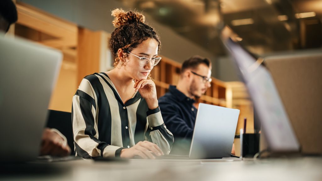 Woman looking pensively at a laptop
