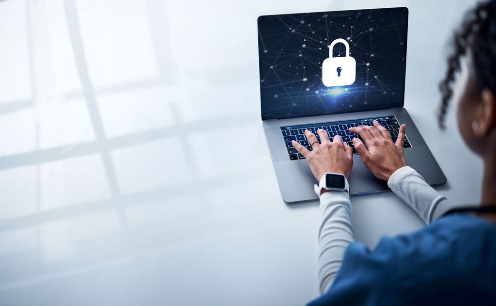 medical professional typing on a laptop with a giant lock on the screen
