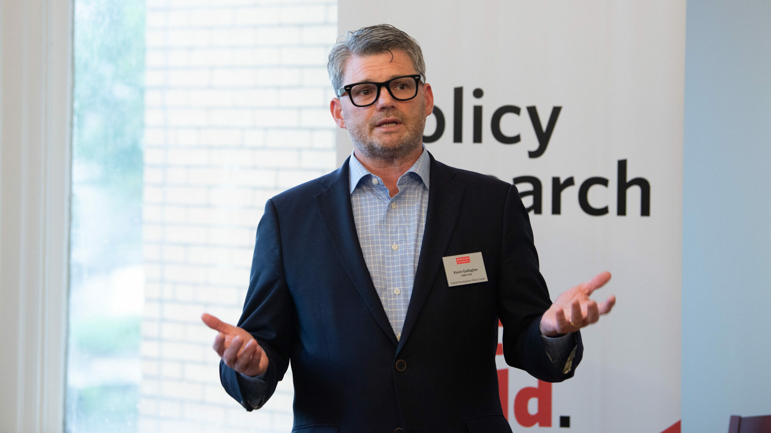 Kevin Gallagher stands in front of a GDP Center banner as he delivers opening remarks at a lecture hosted by the Center.