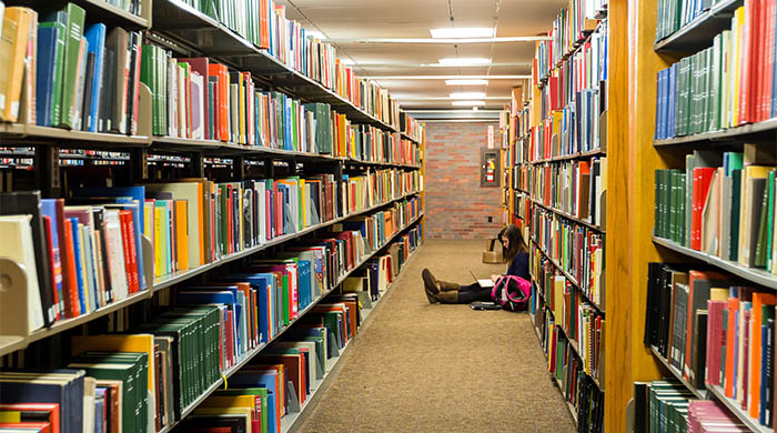 A student studying alone in Mugar Library.