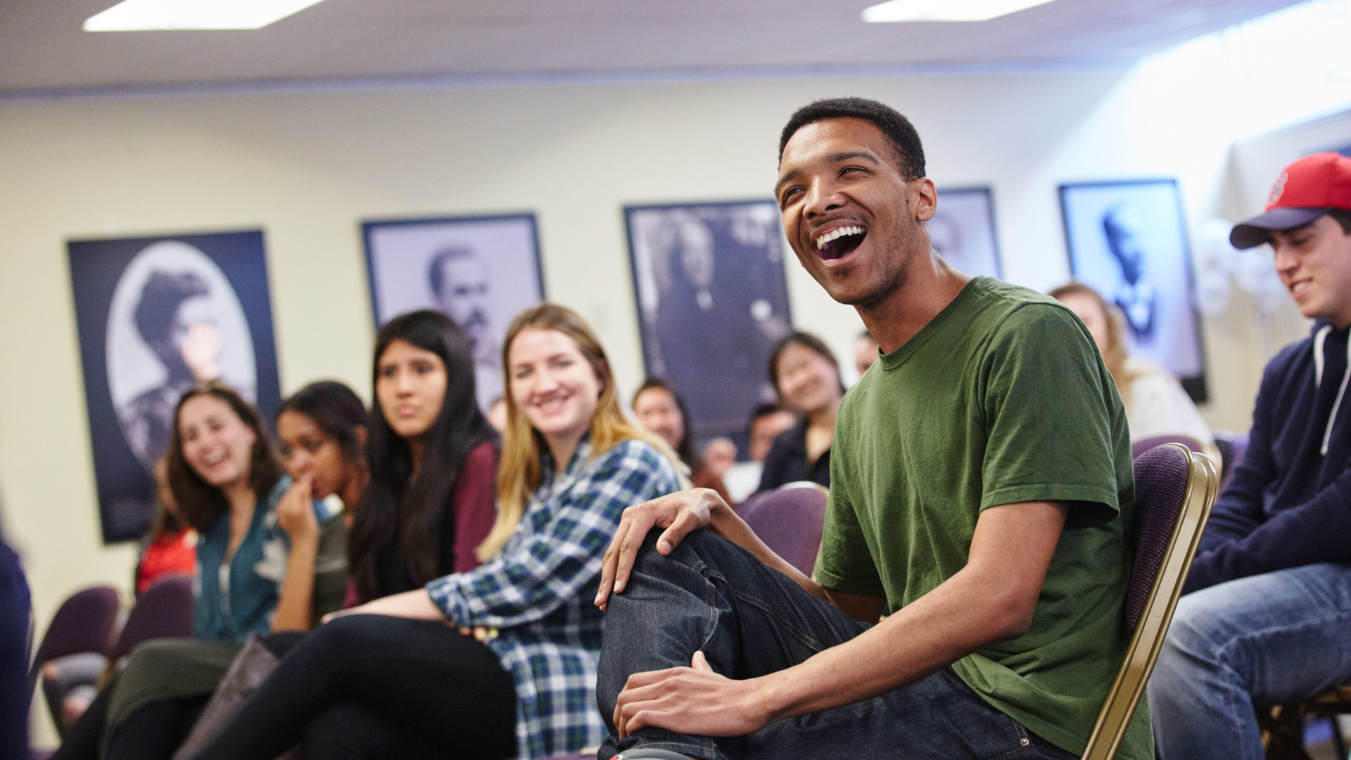 Students looking ahead and smiling during Coffee and Conversation at HTC.