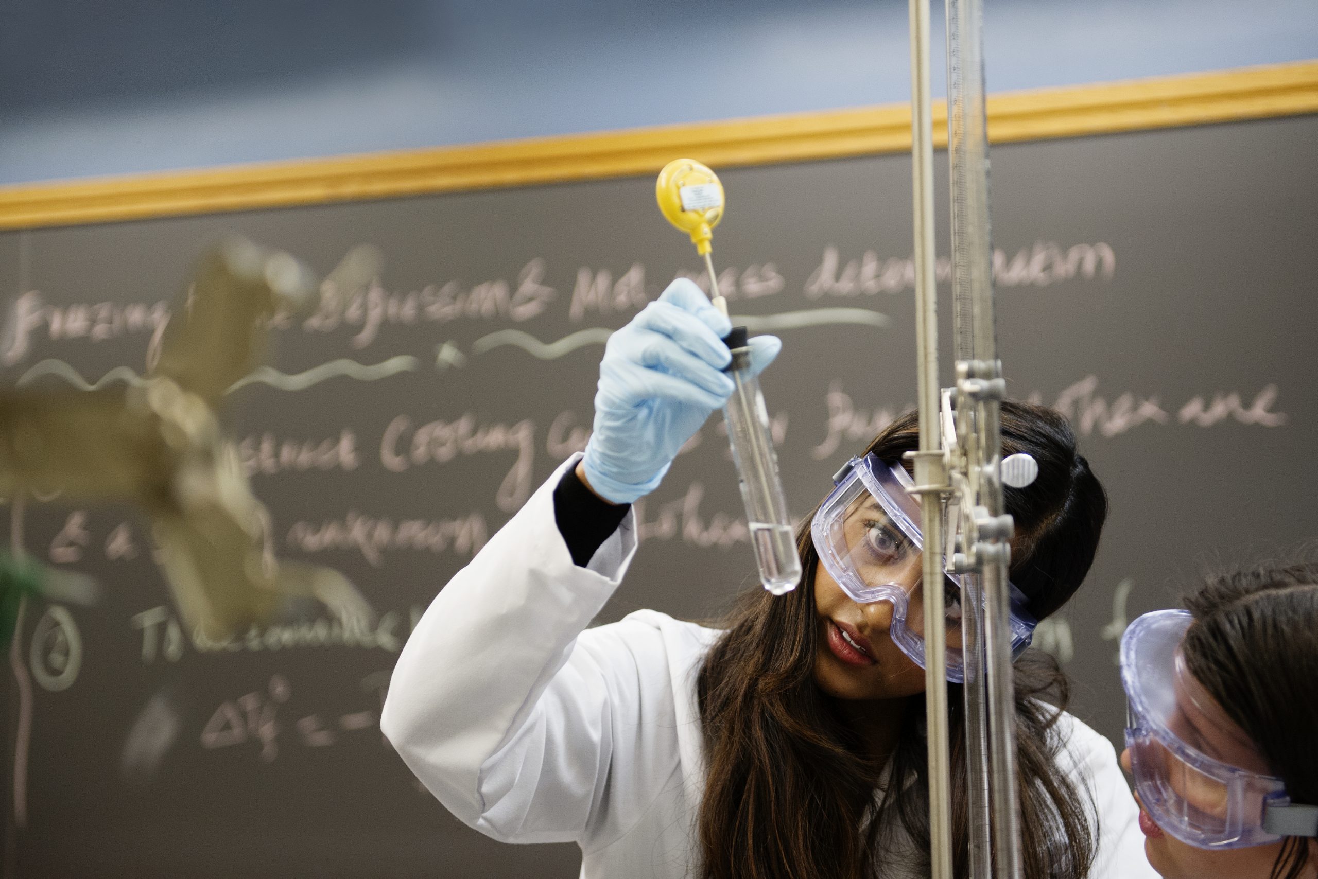 Krishna Singh (CAS 18) checks the liquid in a test tube.