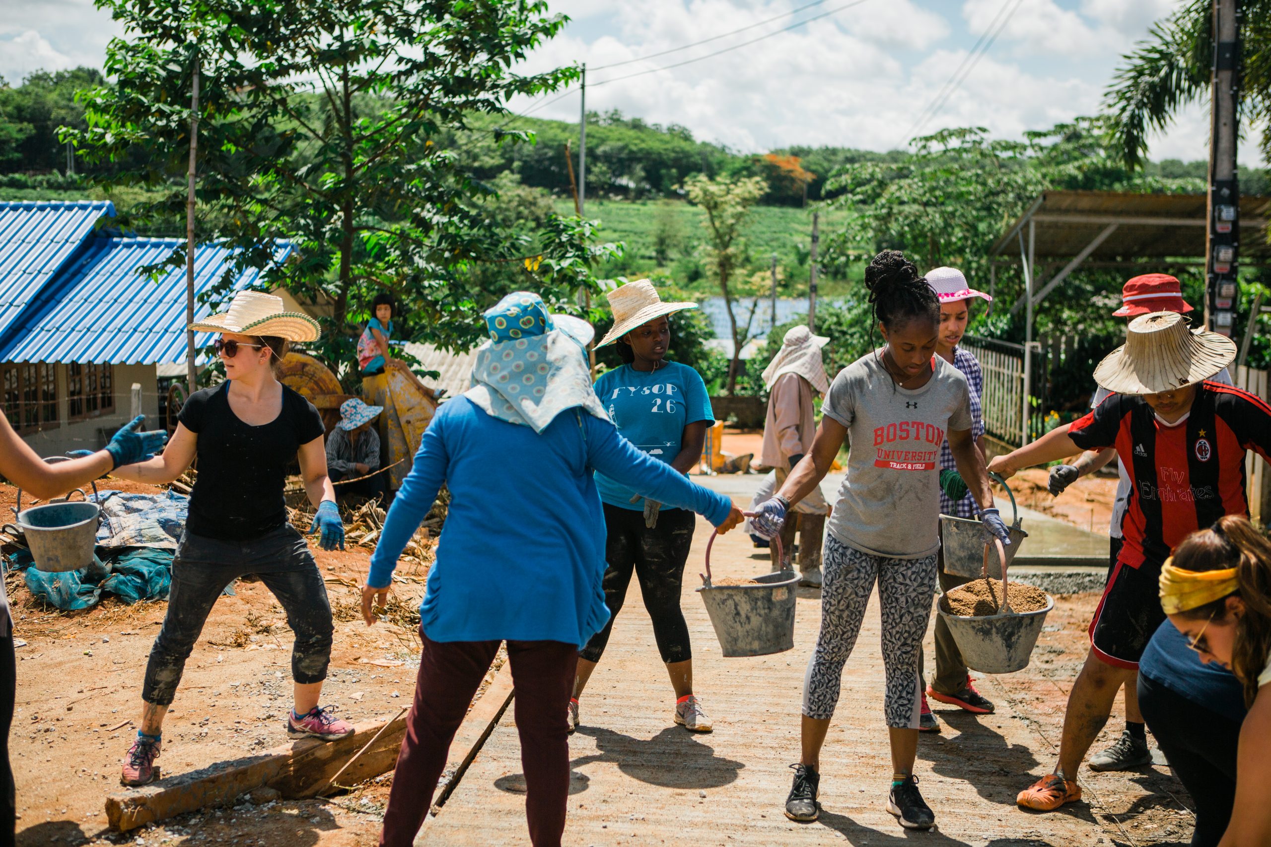 Boston University Sargent School of Health Science and Rehabilitation students help pave a section of road in an Akha hill tribe village in the province of Chiang Rai during a service learning trip to Thailand.