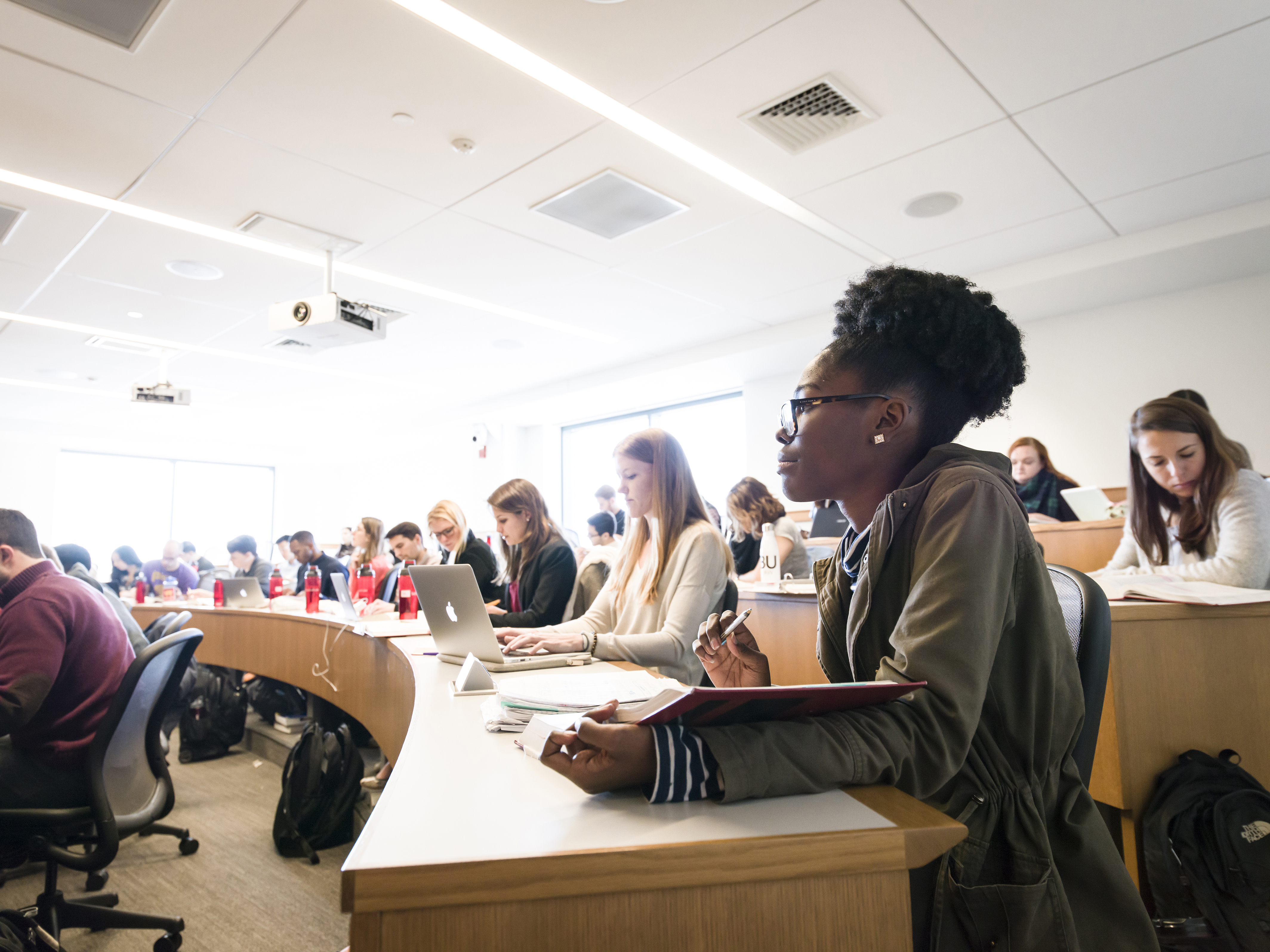 Student takes notes and listens attentively to a class lecture.