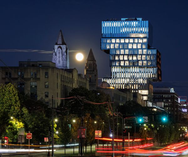 The brightly-lit CDS building stands out against the night sky as cars pass by on Commonwealth Ave.