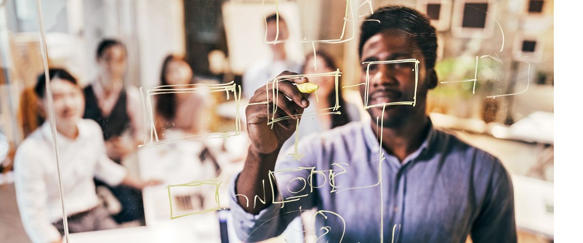 Researcher sketches his ideas on a transparent dry-erase board.