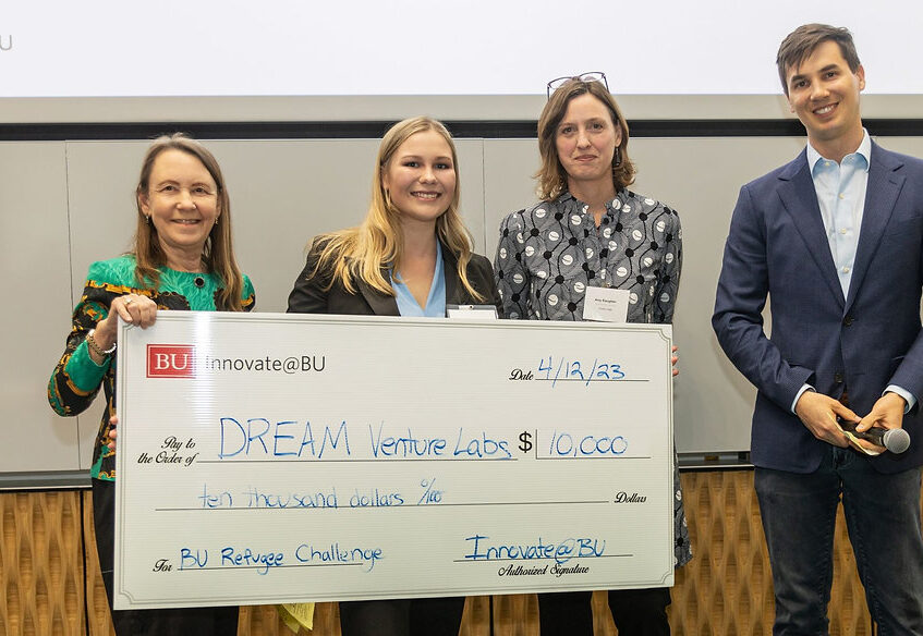 Maria Gorskikh '23 posing with several other people holding a check from Innovate@BU