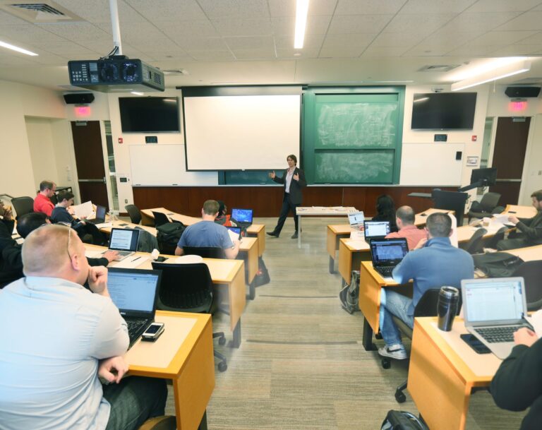 picture of a professor teaching taken from the back of a full classroom