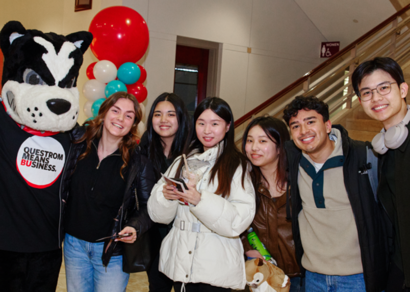 Six questrom students pose with Rhett the Mascot in the Atrium
