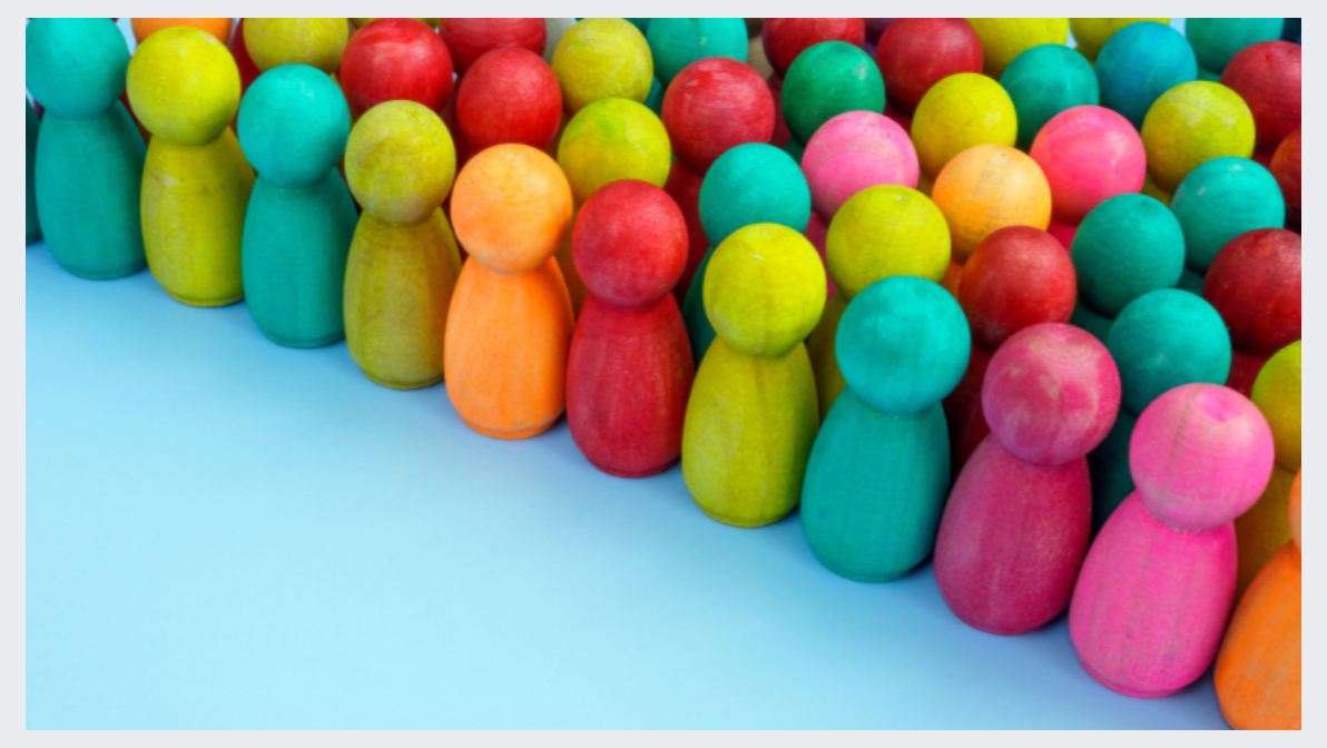 colorful wooden pawns arranged like a crowd of diverse people
