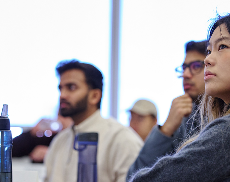 dark haired woman student listening in class