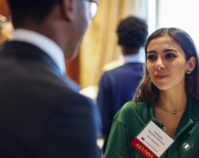 alumna speaks to another at a networking event