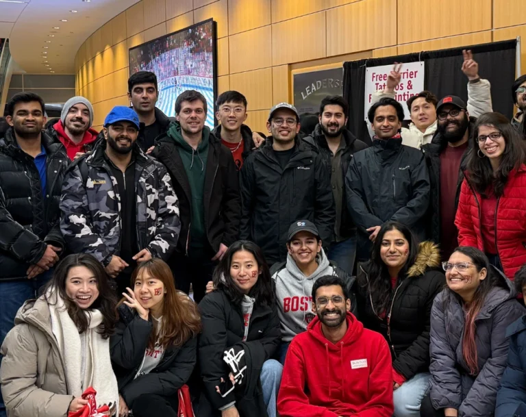 Group of over 20 students miling in red BU merch