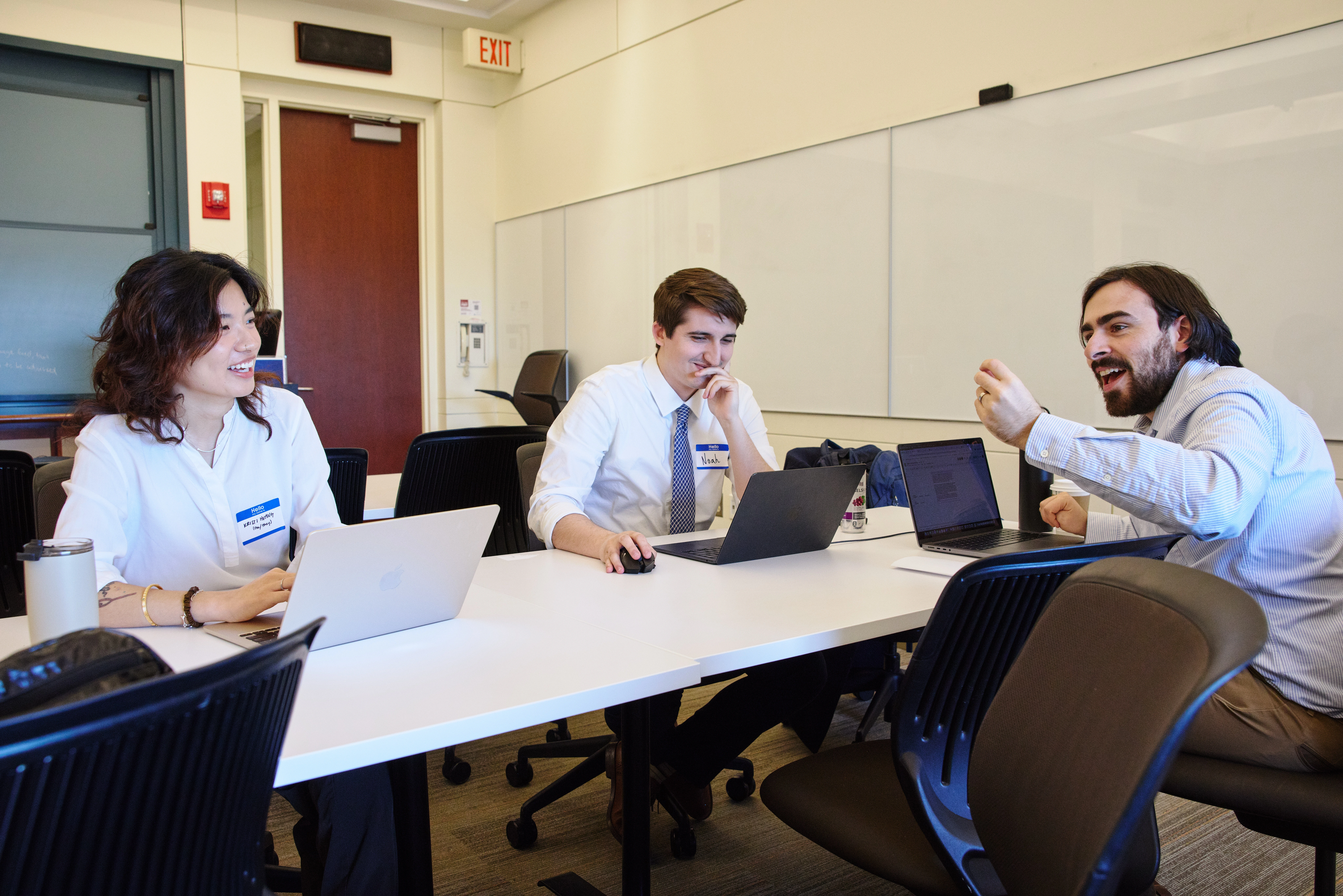 Team working together with laptops in classroom.