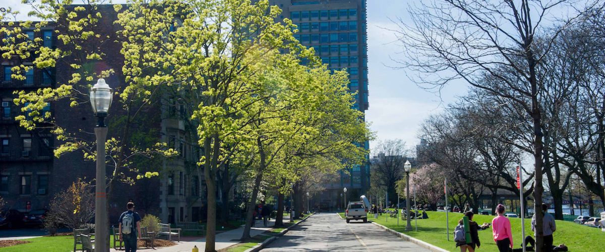 A sunny spring day on the Bay State road section of campus looking at the law building and the BU Beach