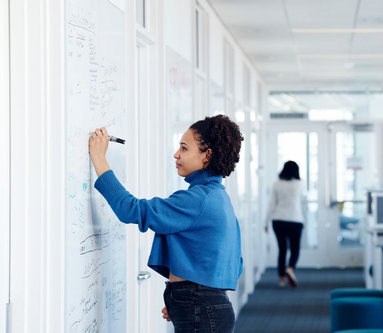 Woman writing on white board