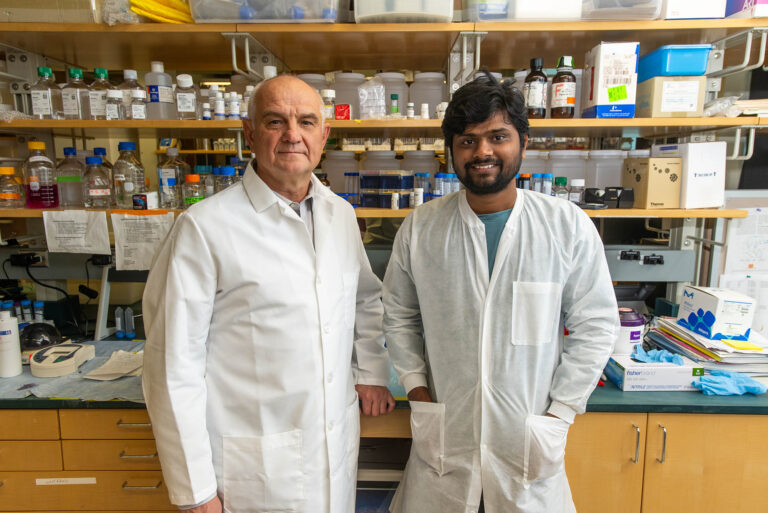 Two lab scientists standing next to each other smiling
