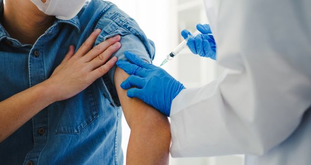 Doctor giving vaccine to patient