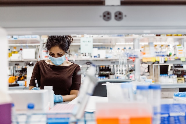Masked researcher working in a lab
