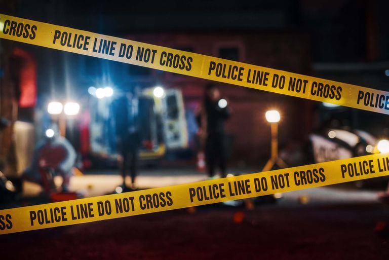 Nighttime crime scene with main focus on police tape