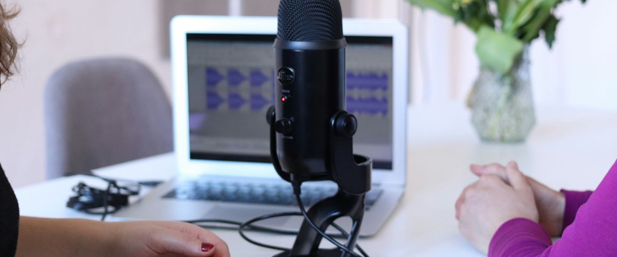Women having an interview in front of a laptop and large black microphone