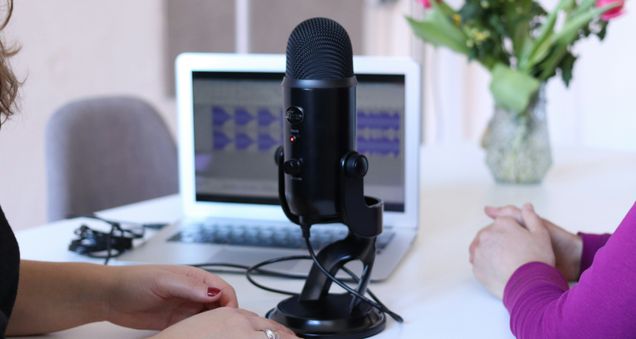 Women having an interview in front of a laptop and large black microphone