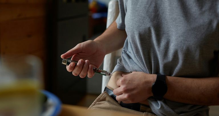 Person with diabetes giving themself a shot in the stomach