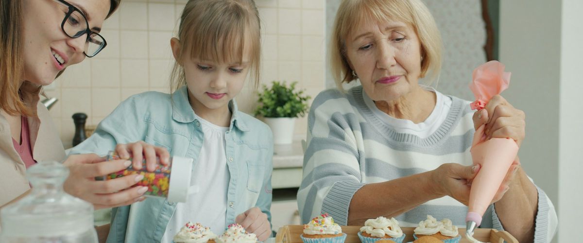 Three generations of women baking cupcakes