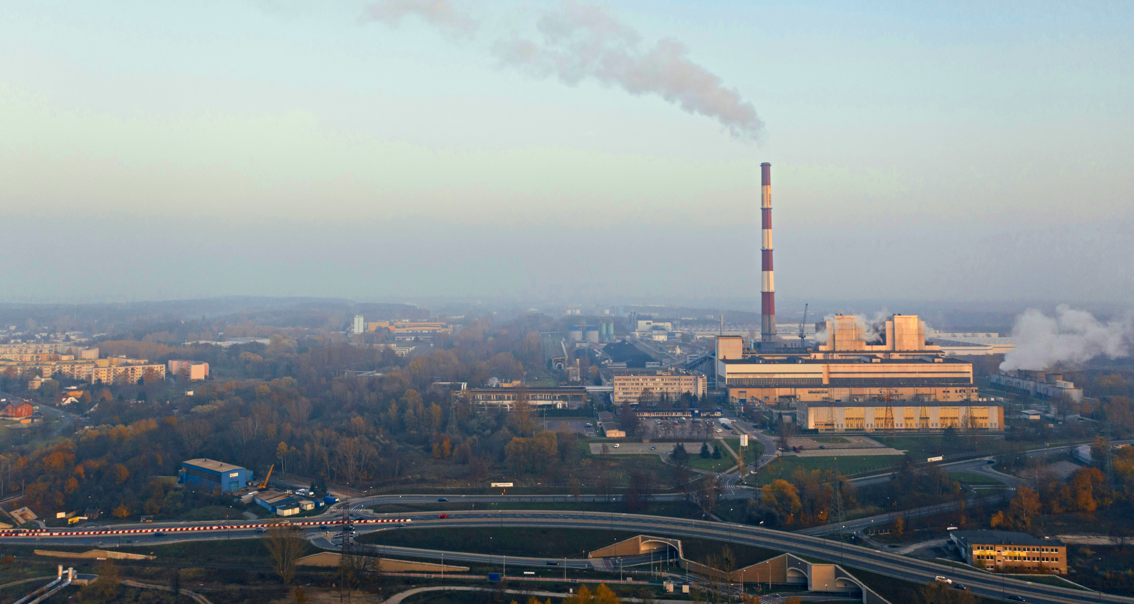 city buildings and power plant under white clouds during daytime