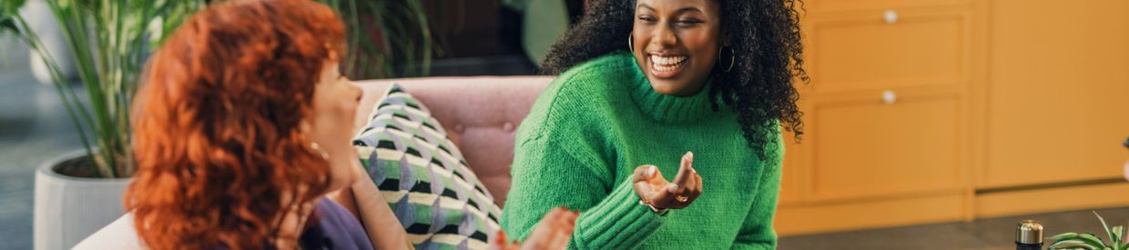 Two women sitting on a couch talking