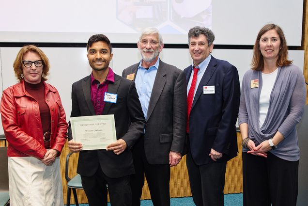 PhD student Pranav Sultania accepts the Anthony Janetos Climate Action Prize on behalf of his team from Janetos’ widow Valerie Gamache and BU’s Dennis Carlberg,