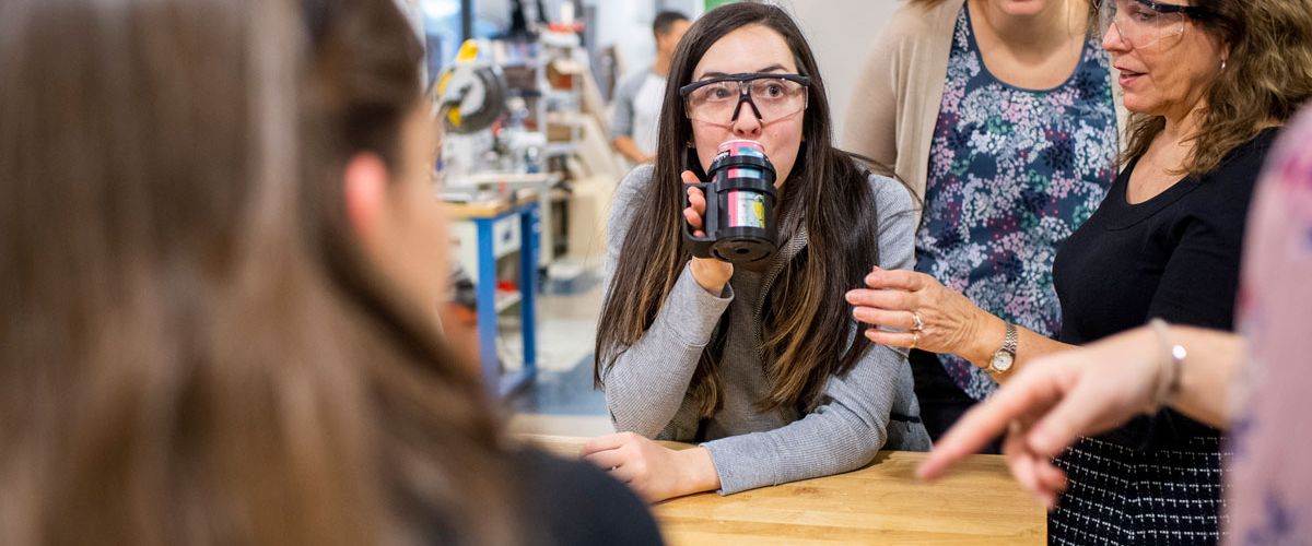 Karen Jacobs (right), Rebecca Khurshid (center), and Amy Aceto (’21) demonstrate a 3-D printed soda holder, designed to assist a person with arthritis. Sargent and engineering students collaborated on the design and production of the device. Photo by Jackie Ricciardi