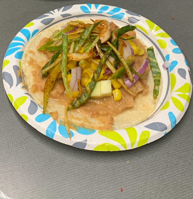 To depict a corn tortilla with seasoned veggies and refried beans