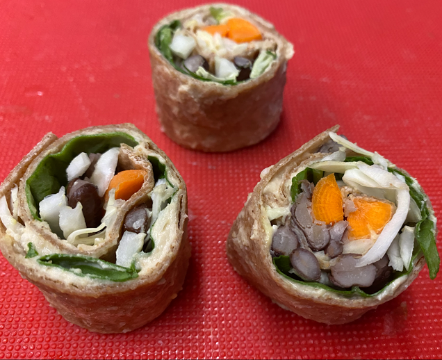 To show the veggie and hummus filling inside the veggie roll ups.