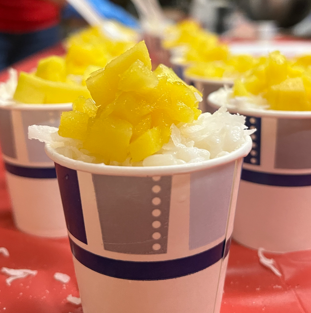 Sticky rice topped with mango in serving cup.