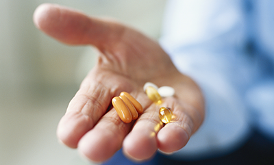 elderly-hand-holding-supplements