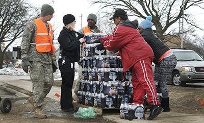 National Guard soldiers work with Flint residents to distribute bottled water to parts of the city affected by the water crisis. 